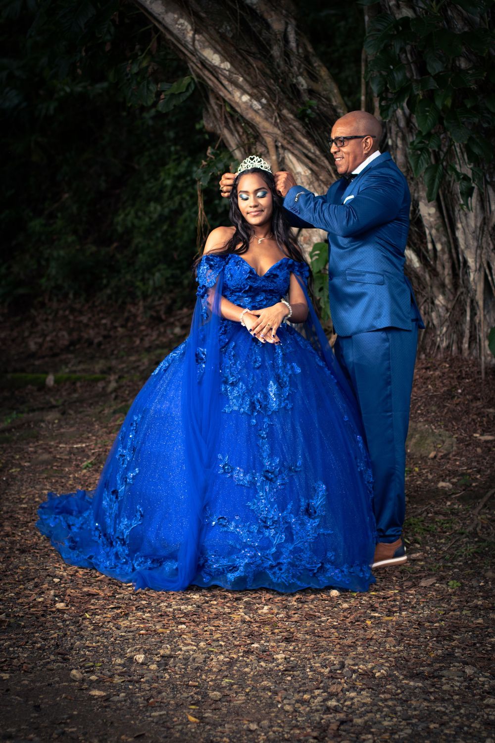 Quinceañera con vestido azul junto a su padre